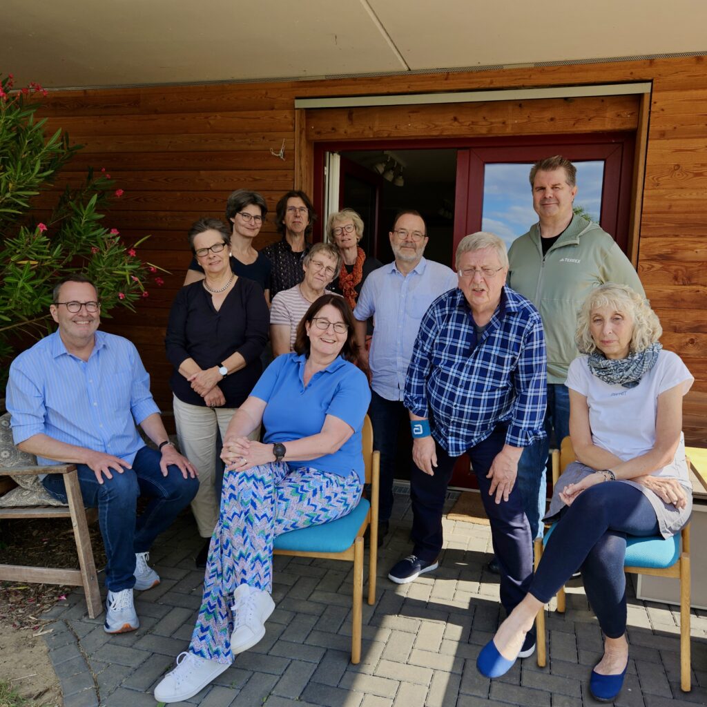 Man sieht eine Gruppe von 11 älteren Personen, die in die Kamera gucken